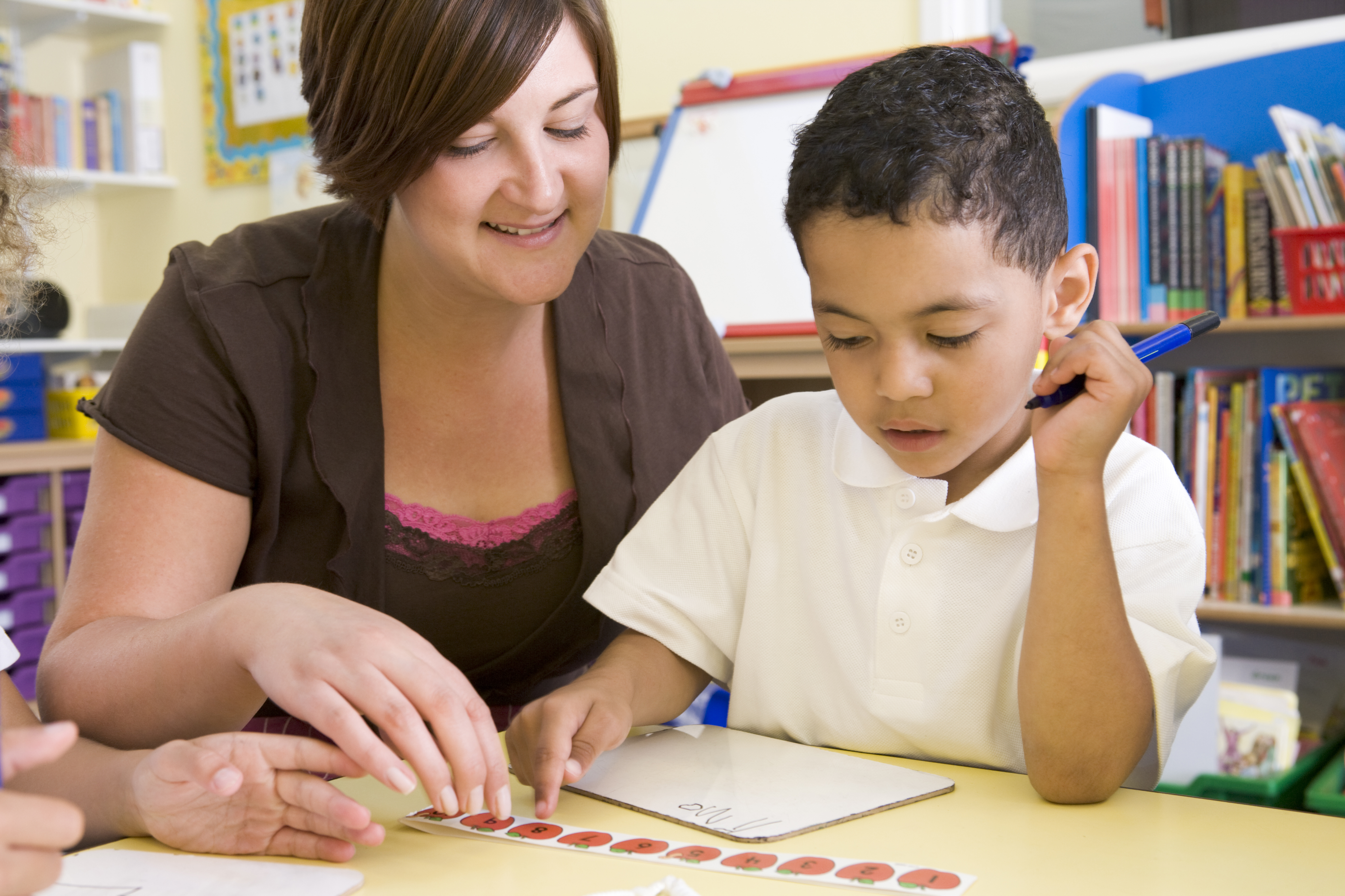 Teacher helping young boy learn numbers