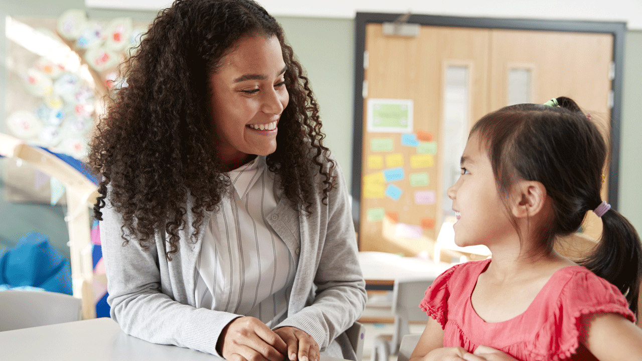 Teacher smiles at student.